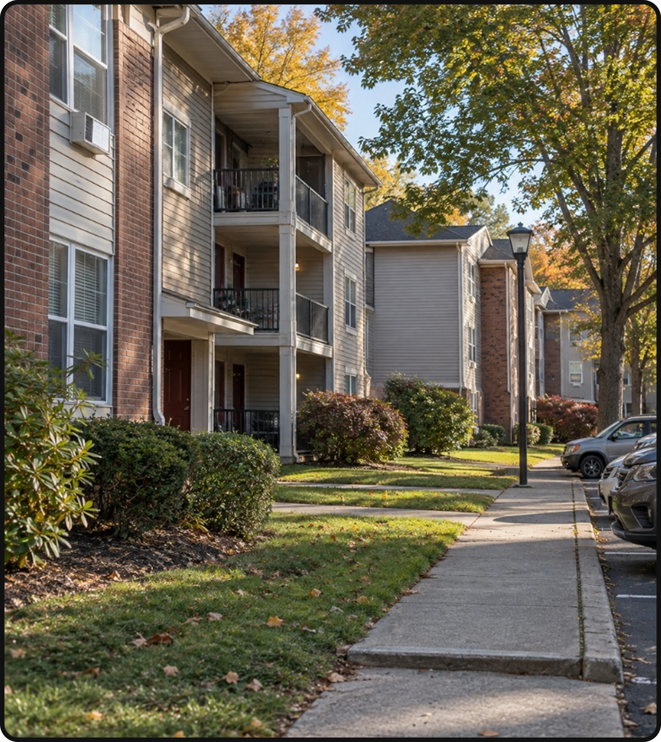 Apartment complex exterior with landscaped grounds, sidewalks and residential buildings